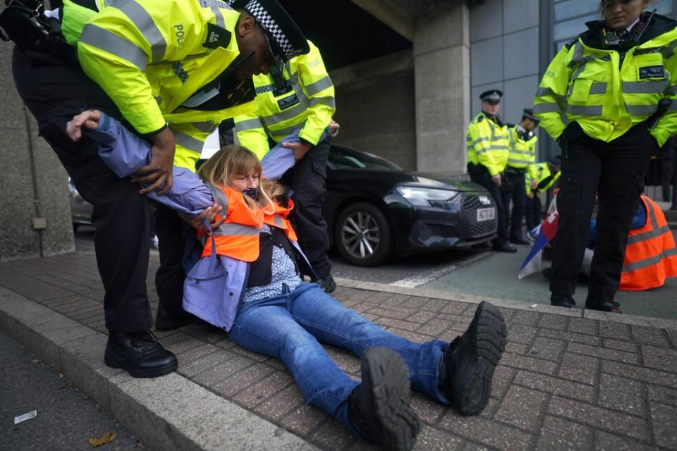 Police removing Insulate Britain protesters after they blocked a road near Canary Wharf in east London (Victoria Jones/PA) (PA Wire)