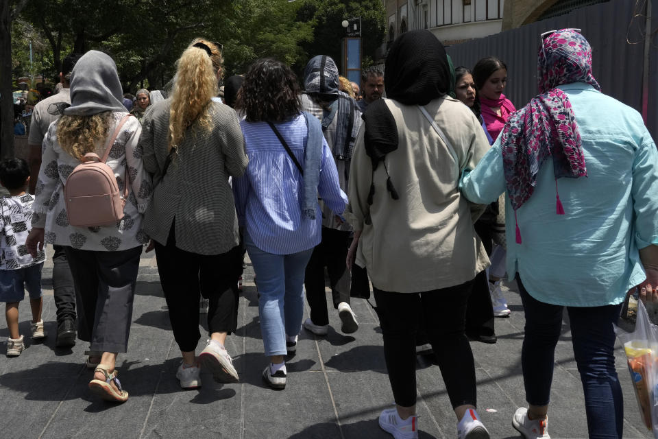 Iranian women, some without wearing their mandatory Islamic headscarf, walk at the old main bazaar of Tehran, Iran, Thursday, June 13, 2024. (AP Photo/Vahid Salemi)