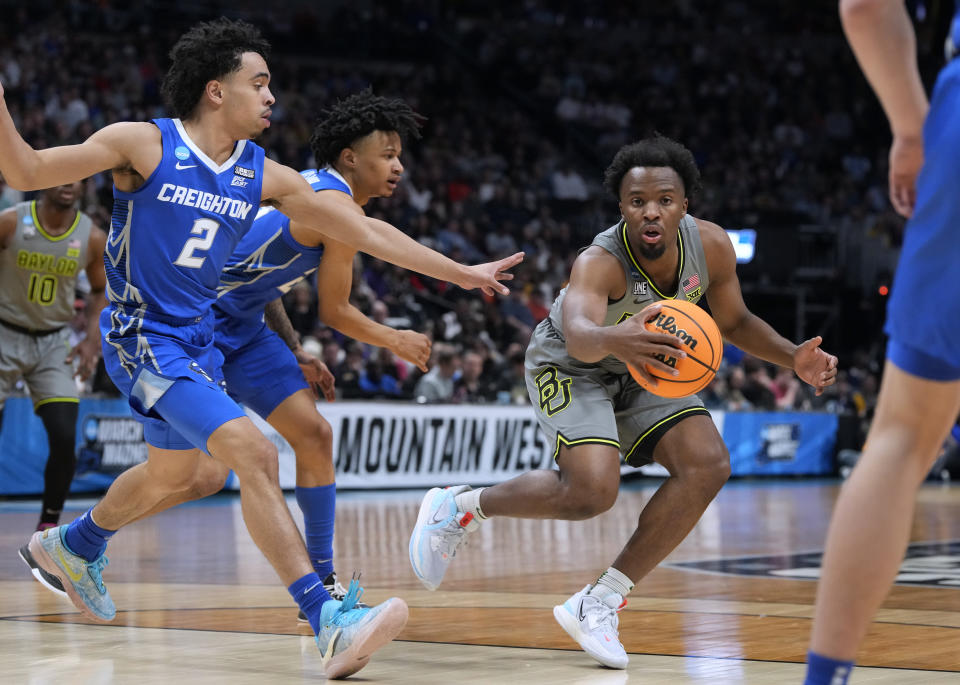 Baylor guard LJ Cryer, right, collects the ball as Creighton guards Ryan Nembhard, front left, and Trey Alexander defend during the first half of a second-round college basketball game in the men's NCAA Tournament on Sunday, March 19, 2023, in Denver. (AP Photo/David Zalubowski)