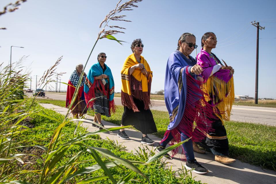 From front left, Donna Carrillo, of Kingsville, and Alfreda Mathieu, of Lafayette, La., spread tobacco to bless Ennis Joslin Road on Saturday, Jan. 13, 2024, in Corpus Christi, Texas. Carrillo walked in honor of her late husband Domingo Castro Carrillo, a Lipan Apache elder.
