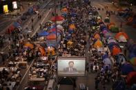 Pro-democracy protestors watch formal talks between student protest leaders and city officials on a video screen near the government headquarters in Hong Kong October 21, 2014. REUTERS/Carlos Barria