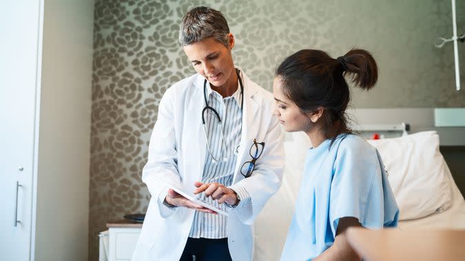 Doctor showing digital tablet to female patient.