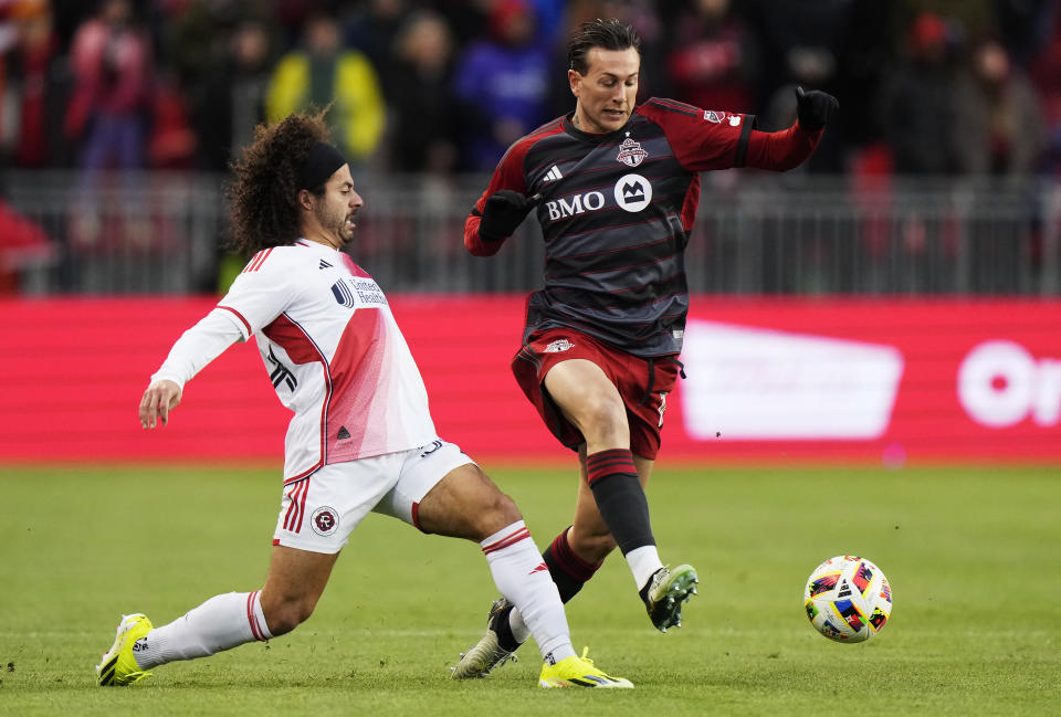 Toronto FC's Federico Bernardeschi, right, tries to get around New England Revolution's Ryan Spaulding, left, during first-half MLS soccer match action in Toronto, Saturday, April 20, 2024. (Frank Gunn/The Canadian Press via AP)