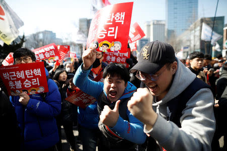 People celebrate after hearing that President Park Geun-hye's impeachment was accepted in front of the Constitutional Court in Seoul, South Korea, March 10, 2017. REUTERS/Kim Hong-Ji