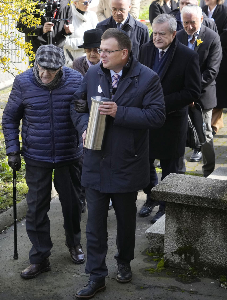 Albert Stankowski, right, the director of the Warsaw Ghetto Museum, walks with Waclaw Kornblum,left, a Polish Holocaust survivor, followed by Polish Culture Minister Piotr Glinski, second right, duringa ceremony for the burial of a "time capsule" on the grounds of the museum in Warsaw, Poland, on Tuesday April 18, 2023. The time capsule contains memorabilia and a message to future generations. It was buried on the grounds of a former children's hospital, a building that will house Warsaw Ghetto Museum, which is scheduled to open in three years. Tuesday's ceremony comes on the eve of the 80th anniversary of the Warsaw Ghetto Uprising, the largest single Jewish revolt against German forces during the Holocaust. (AP Photo/Czarek Sokolowski)