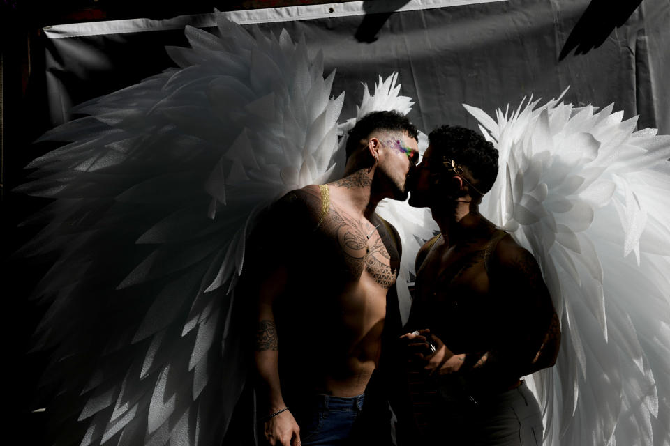 Men donning angel wings share a kiss in downtown Buenos Aires, Argentina, Saturday, Nov. 4, 2023, where thousands have gathered to commemorate the 32nd annual Pride Parade. (AP Photo/Rodrigo Abd)