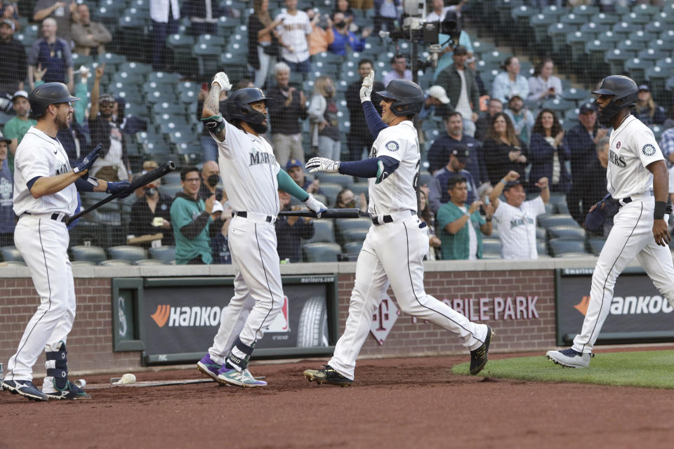 Seattle Mariners' Dylan Moore, second from right, celebrates with Tom Murphy, J.P. Crawford and Kyle Lewis, from left, after Moore's three-run home run during the fourth inning of the team's baseball game against the Cleveland Indians, Saturday, May 15, 2021, in Seattle. (AP Photo/Jason Redmond)