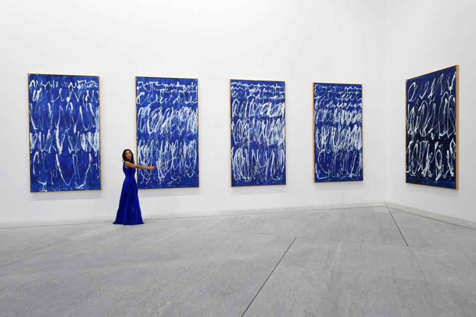 A woman takes a selfie in front of part of a series of nine panels titled "Untitled I-IX" by American painter Cy Twembly: GIUSEPPE CACACE/AFP via Getty Images