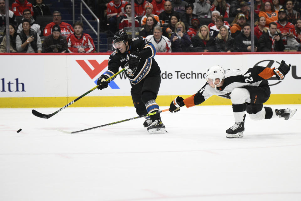 Washington Capitals right wing T.J. Oshie (77) shoots past Philadelphia Flyers defenseman Nick Seeler (24) during the first period of an NHL hockey game Saturday, Jan. 14, 2023, in Washington. (AP Photo/Nick Wass)