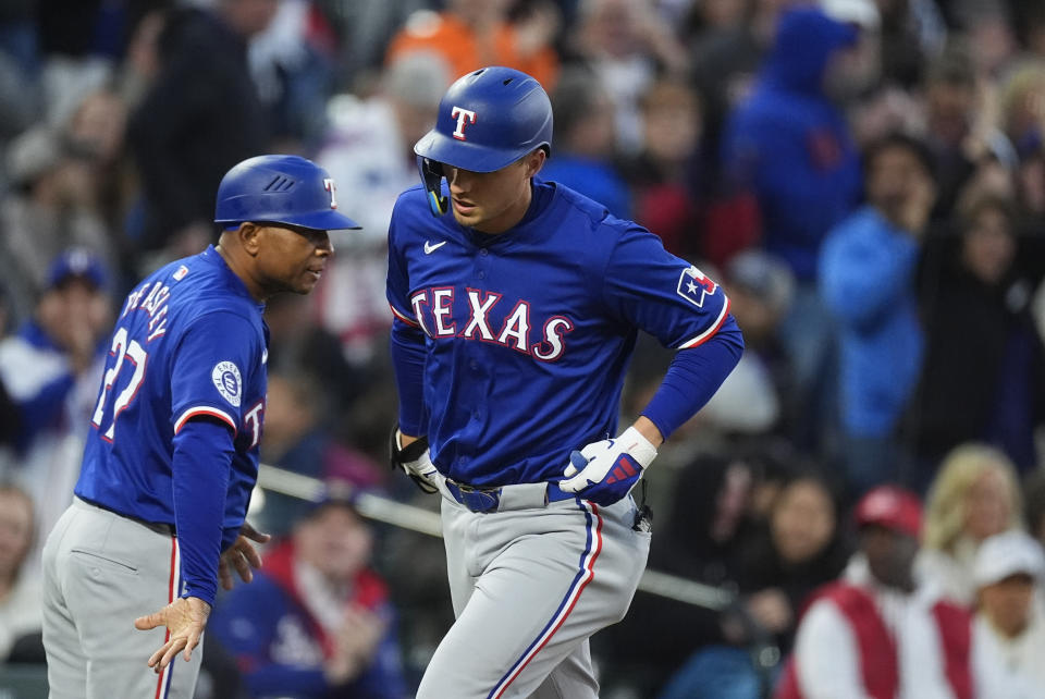 Texas Rangers' Corey Seager, right, is congratulated by third base coach Tony Beasley, left, after hitting a solo home run off Colorado Rockies starting pitcher Austin Gomber in the sixth inning of a baseball game Friday, May 10, 2024, in Denver. (AP Photo/David Zalubowski)
