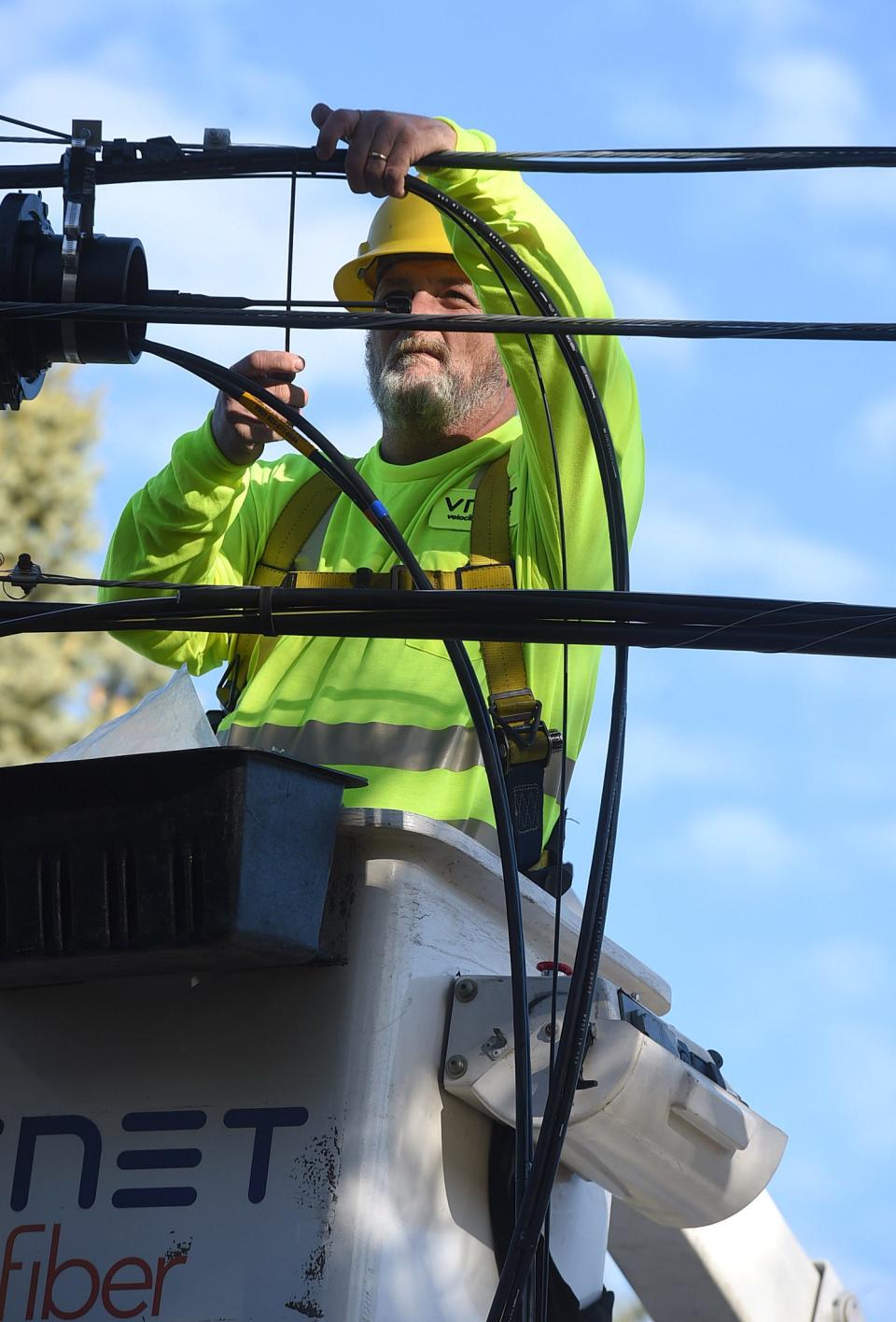 In this file photo, Kevin Learn, a fiber splicer with Velocity Network, installs fiber-optic cable outside a home in the 7000 block of Garfield Avenue in Harborcreek Township on March 24, 2021.