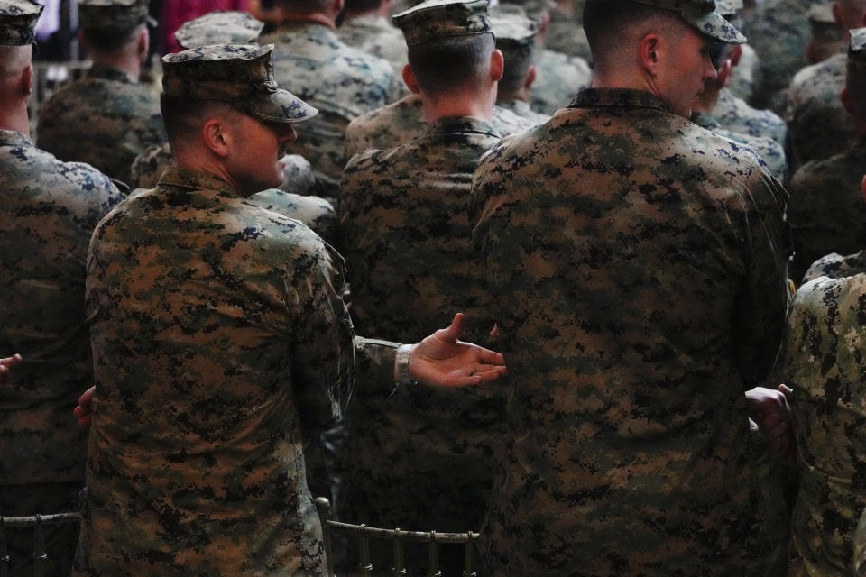 A U.S. trooper reaches out to link arms with his comrade during the opening ceremonies of a joint military exercise flag called "Balikatan," a Tagalog word for "shoulder-to-shoulder," at Camp Aguinaldo military headquarters Tuesday, April 11, 2023, in Quezon City, Philippines. The United States and the Philippines on Tuesday launch their largest combat exercises in decades that will involve live-fire drills, including a boat-sinking rocket assault in waters across the South China Sea and the Taiwan Strait that will likely inflame China. (AP Photo/Aaron Favila)