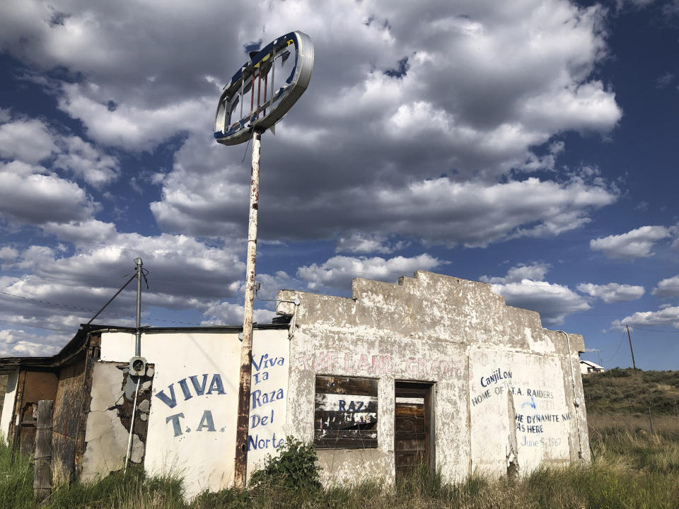 In this June 28, 2020, photo, an abandoned gas station in Tierra Amarilla, N.M., is shown with graffiti honoring the 1967 courthouse raid in the town by armed Mexican American land grant activists. Activists and cities are left wondering what to do with empty spaces that once honored historic figures tied to racism as statues and monuments fall. New Mexico has no formal public art honoring the Tierra Amarilla raid, which helped spark the Chicano Movement. (AP Photo/ Russell Contreras)
