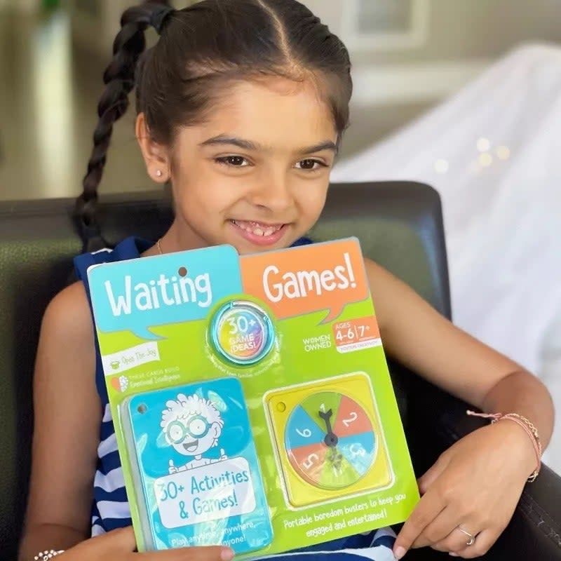 Young girl holding 'Waiting Games' activity book with over 30 exercises, for ages 4-7