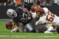 Washington Football Team's Daniel Wise (92), Deshazor Everett (22) and Jamin Davis (52) tackle Las Vegas Raiders running back Kenyan Drake (23) during the first half of an NFL football game, Sunday, Dec. 5, 2021, in Las Vegas. (AP Photo/David Becker)