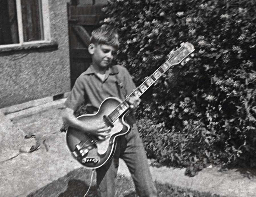 Young Peter Frampton plays guitar in his garden