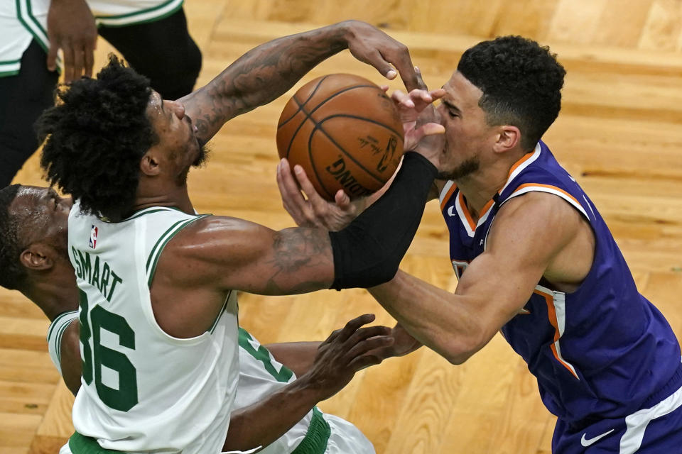 Boston Celtics guard Marcus Smart (36) and Phoenix Suns guard Devin Booker (1) compete for the ball in the first half of an NBA basketball game, Thursday, April 22, 2021, in Boston. (AP Photo/Elise Amendola)