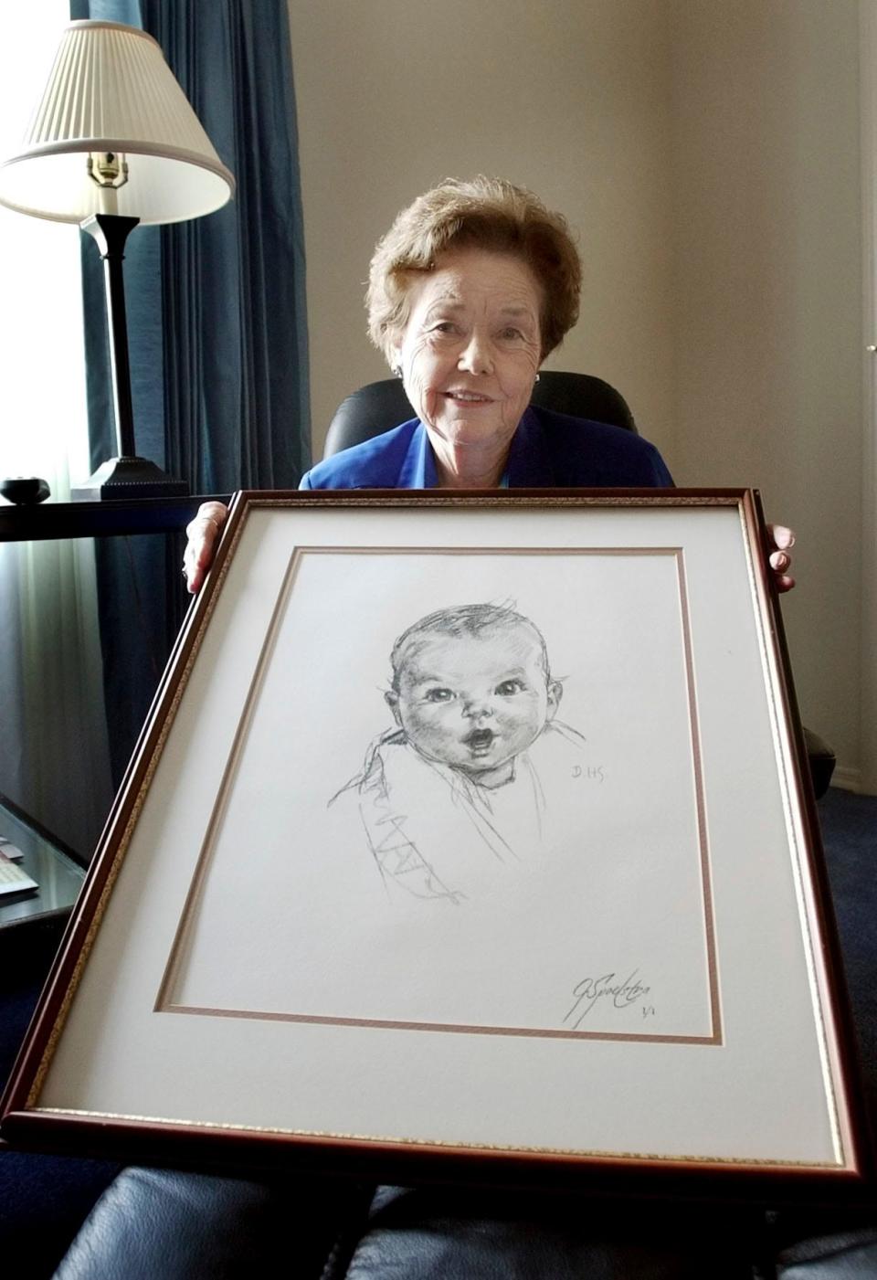 Ann Turner Cook, poses at her Tampa, Fla., home on Feb. 4, 2004, with a copy of her photo that is used on all Gerber baby food products.