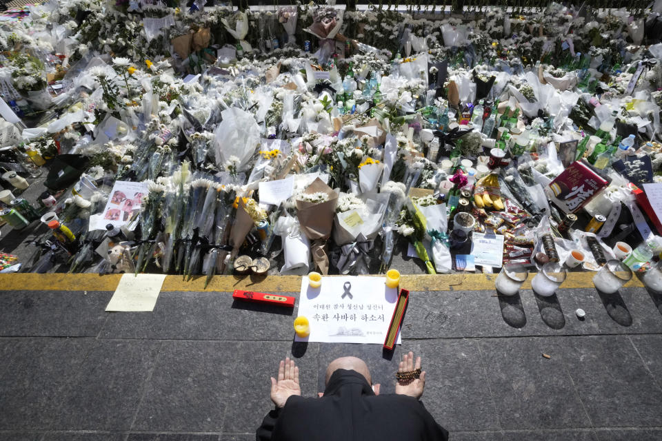 A Buddhist monk prays for victims of a deadly accident during Saturday night's Halloween festivities, at a makeshift flower-laying area set up near the scene of the accident in Seoul, South Korea, Wednesday, Nov. 2, 2022. South Korean officials admitted responsibility and apologized on Tuesday for failures in preventing and responding to a Halloween crowd surge that killed more than 150 people and left citizens shocked and angry. (AP Photo/Ahn Young-joon)