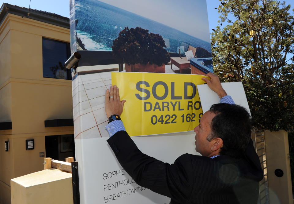 To go with a feature story Australia-property by Madeleine Coorey Eastern suburbs real estate agent Daryl Rosen puts a 'sold' sticker over the advertising signage after another successful multi-million dollar house auction in Sydney on May 8, 2010. In Australia's largest cities of Sydney and Melbourne, the growth in property prices has been enough to ensure many prospective home owners are priced out of the market before they make their first tentative bid.  AFP PHOTO / Torsten BLACKWOOD (Photo credit should read TORSTEN BLACKWOOD/AFP via Getty Images)