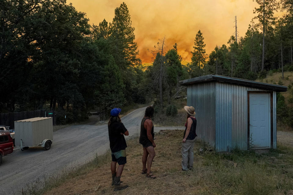 Residents who live along Buckingham Mountain Road watch as the Oak Fire burns near their home, which is located between Midpines and Mariposa, Calif., on July 22.<span class="copyright">Tracy Barbutes—Reuters</span>