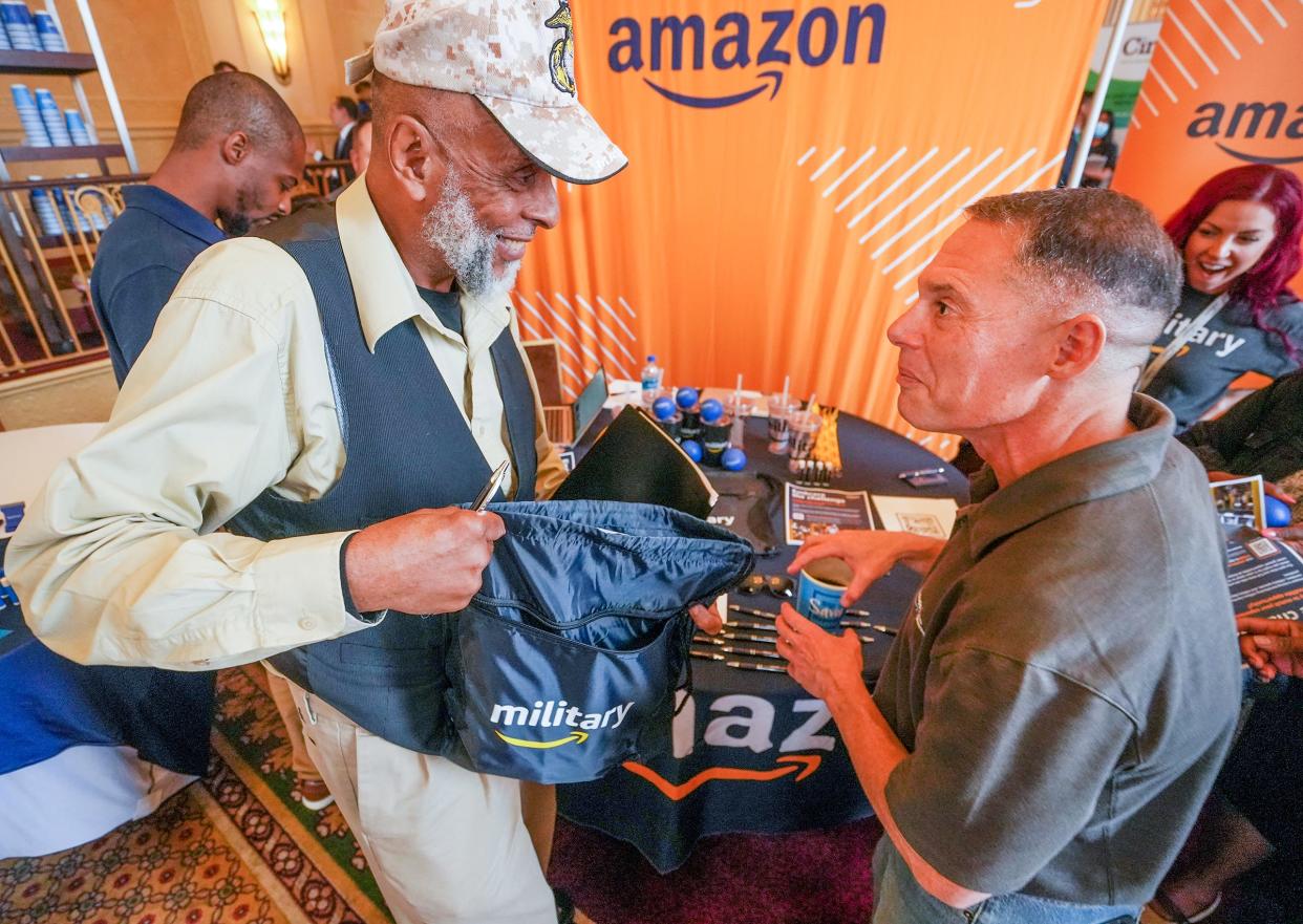 Reginald Jones, left, receives a bag from Matthew Gorbaty, senior Human Resources investigator for Amazon, during the American Legion Convention Thursday, Aug. 25, 2022, at Hilton Milwaukee City Center in Milwaukee. Jones served as an aviation technician in the Marine Corps from 1984-1988. After serving 25 years in the Marine Corps, Gorbaty now helps recruit veterans. "That's why I come to the veteran events," he explained. "Amazon was really good to me, so I want to help my fellow veterans the way they (Amazon) helped me."