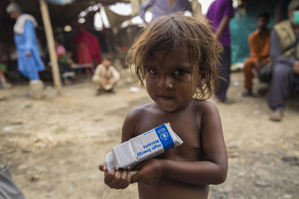 Yasmin, three, holds a packet of high-energy biscuits, part of a ration package from WFP, in Koi Goth, a slum area in KarachiSaiyna Bashir/Arete/WFP