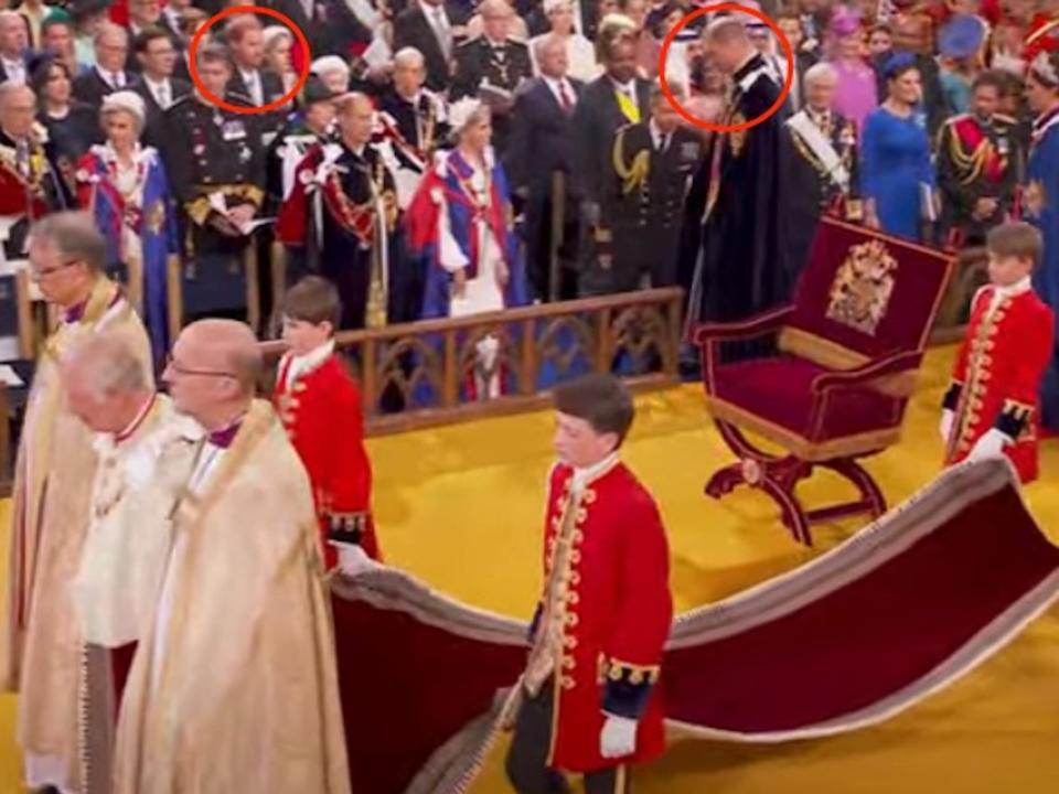 Prince Harry looks at Prince William as he enters King Charles III's coronation.