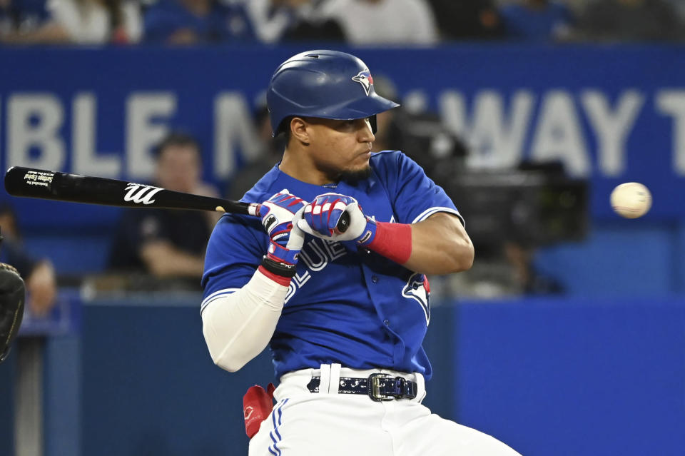 Toronto Blue Jays' Satiago Espinal ducks away from a high, inside pitch from Baltimore Orioles starter Dean Kremer during the fourth inning of a baseball game Tuesday, Aug. 16, 2022, in Toronto. (Jon Blacker/The Canadian Press via AP)