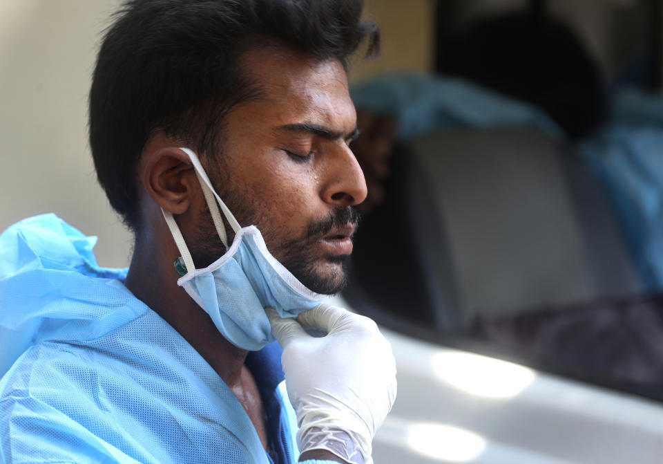 Izhaar Hussain Shaikh, center, an ambulance driver who works for HelpNow, an initiative to help the stretched services of first responders, takes a deep breathe as he waits for hours outside a hospital to admit a COVID-19 patient in Mumbai, India May 29, 2020. It’s an exhausting job and Shaikh's daily shifts are grueling, sometimes even stretching to 16 hours. For a city that has a history of shortage of ambulances and where coronavirus pandemic has claimed hundreds of lives, putting the health care system under immense strain, every help counts. (AP Photo/Rafiq Maqbool)