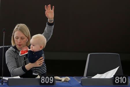 FILE PHOTO: Swedish Member European Parliament Jytte Guteland holds her baby as she takes part in a voting session at the European Parliament in Strasbourg, France, March 14, 2017. REUTERS/Vincent Kessler/File Photo