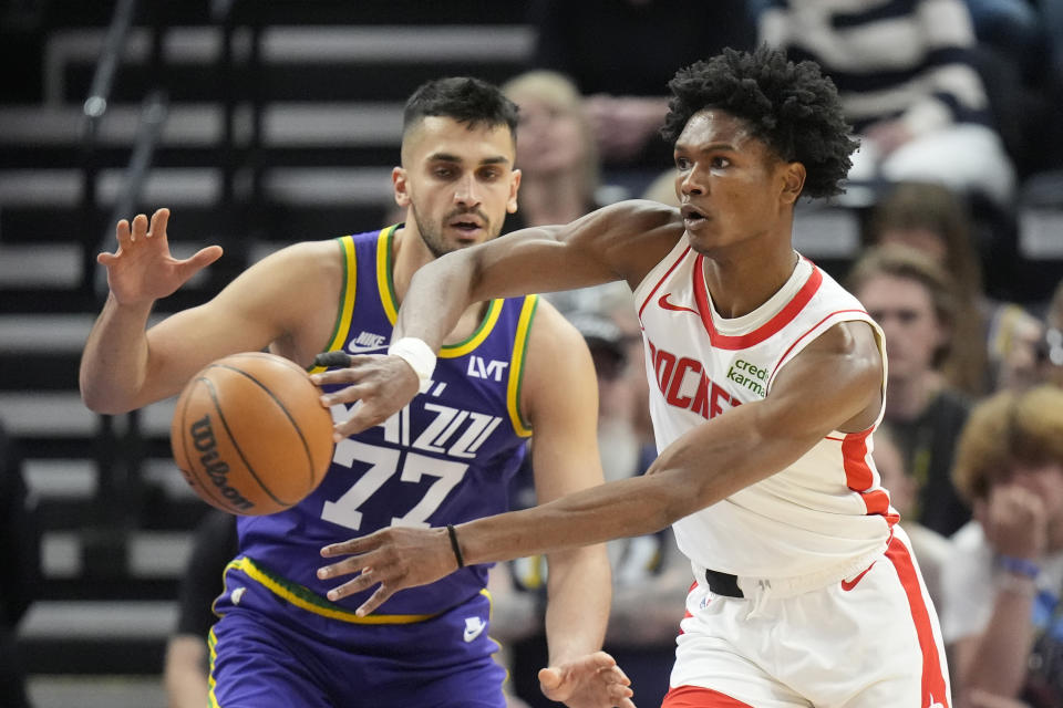 Houston Rockets forward Amen Thompson, right, passes the ball as Utah Jazz center Omer Yurtseven defends during the first half of an NBA basketball game Thursday, April 11, 2024, in Salt Lake City. (AP Photo/Rick Bowmer)