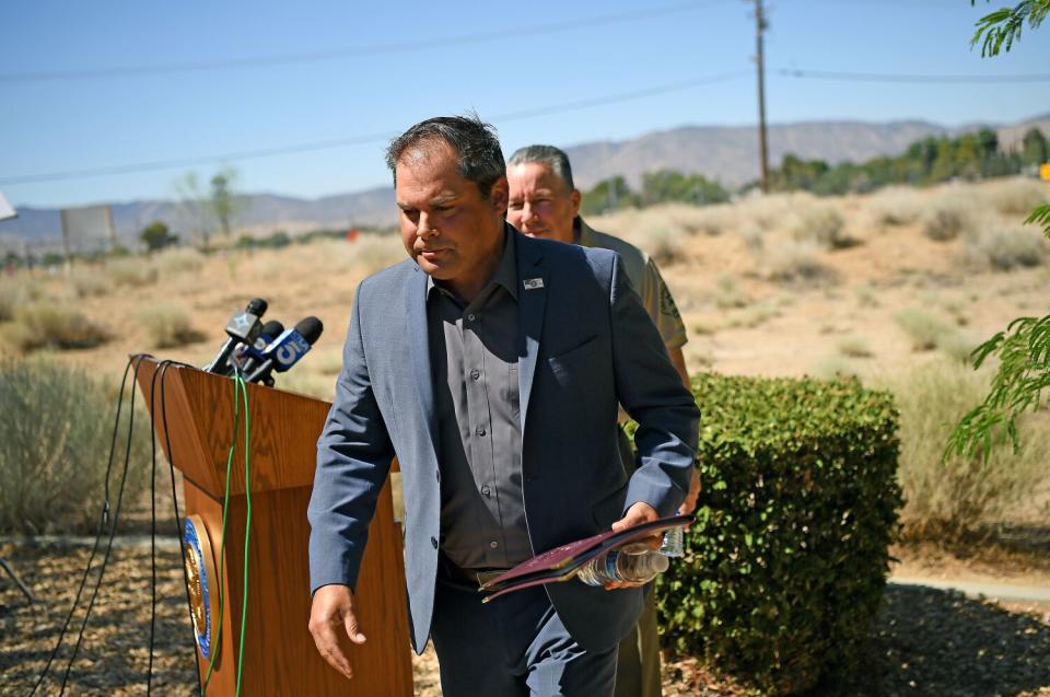 Two men stand by a lectern with microphones.