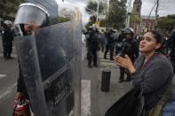 A woman pleads for no more violence to a riot federal police officer after striking members of the teachers' union CNTE were evicted from Zocalo Square in downtown Mexico City September 13, 2013. (REUTERS/Tomas Bravo)