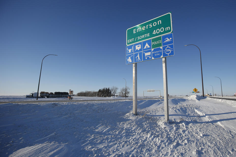 Road signage is posted just outside of Emerson, Manitoba on Thursday, Jan. 20, 2022. A Florida man was charged Thursday with human smuggling after the bodies of four people, including a baby and a teen, were found in Canada near the U.S. border, in what authorities believe was a failed crossing attempt during a freezing blizzard. The bodies were found Wednesday in the province of Manitoba just meters (yards) from the U.S. border near the community of Emerson. (John Woods/The Canadian Press via AP)