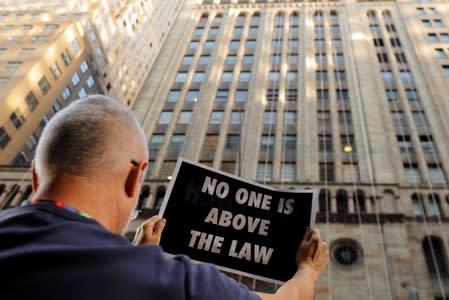 Demonstrators hold protest signs as part of a demonstration in support of impeachment hearings in New York