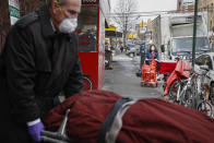 Funeral director Tom Cheeseman retrieves a body on a house call, Friday, April 3, 2020, in the Brooklyn borough of New York. Cheeseman is picking up as many as 10 bodies per day. Most bodies come from homes and hospitals. (AP Photo/John Minchillo)