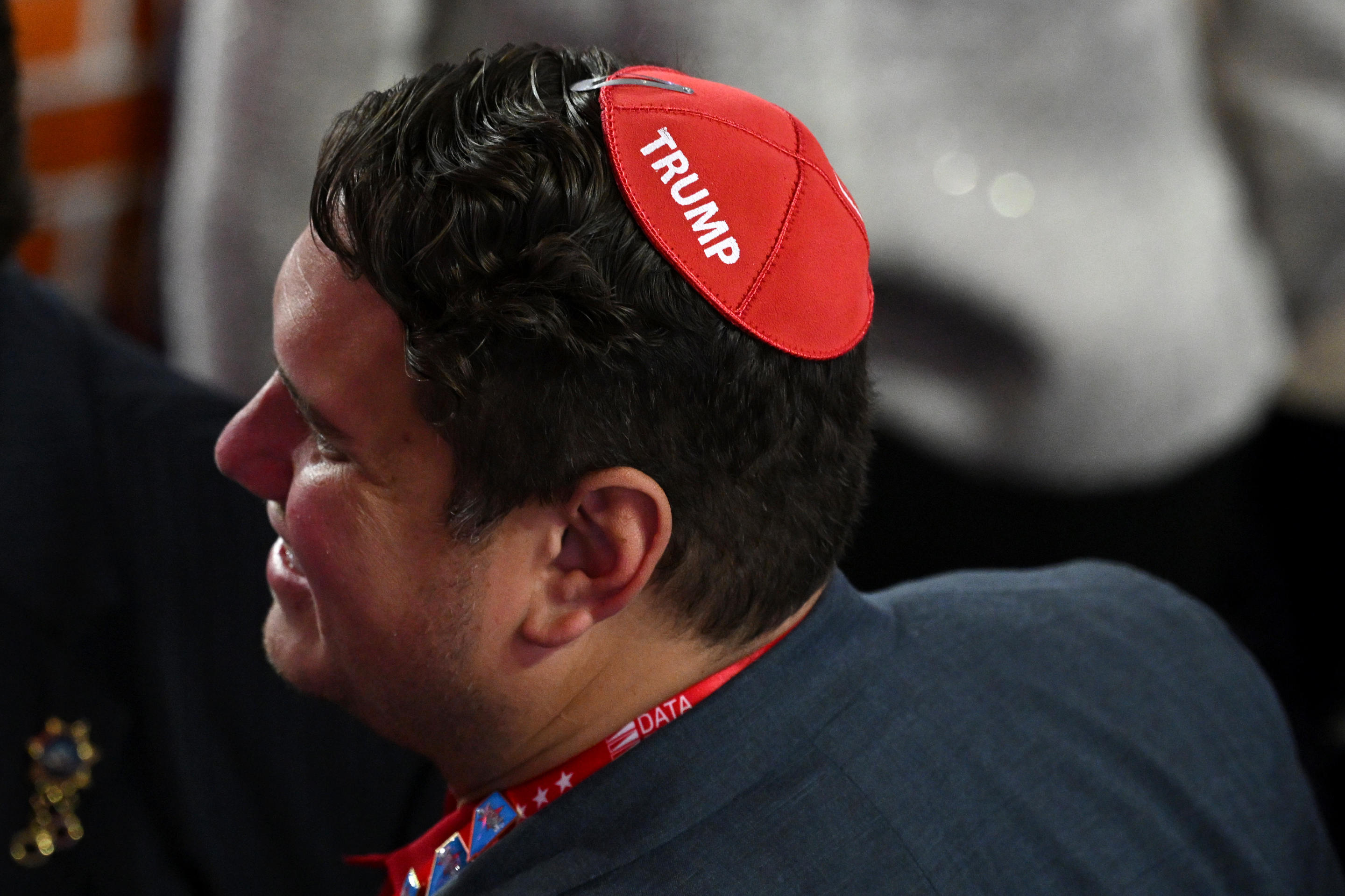 A man wearing a Trump yarmulke smiles on the convention floor. 