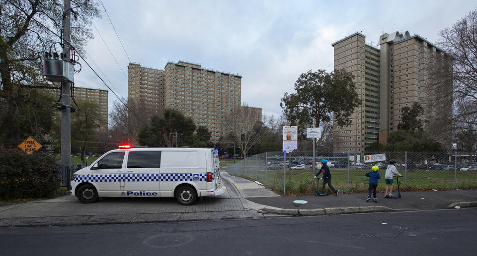 Children play near police patrols outside the public housing towers where 3000 residents are in hard lockdown. Source: AAP