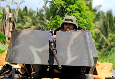 A government soldier atop an armoured personnel carrier is posted along a main highway in Pantar town, Lanao del Norte, after residents started to evacuate their hometown of Marawi city, southern Philippines May 24, 2017. REUTERS/Romeo Ranoco