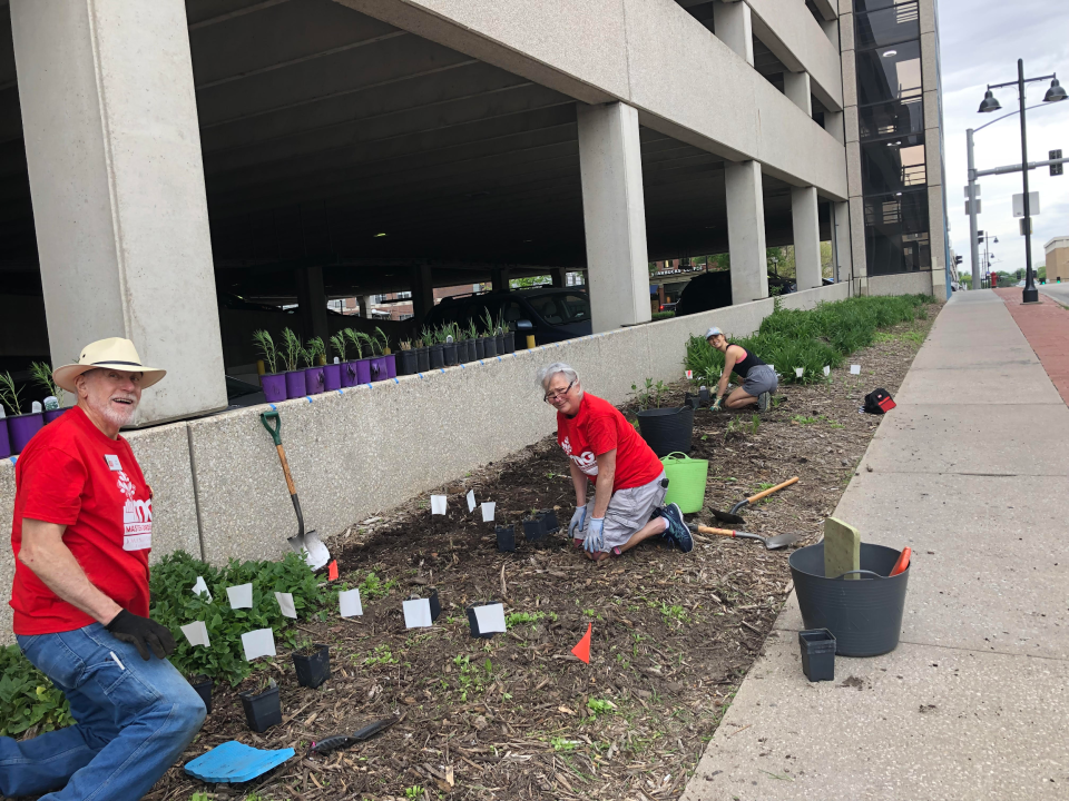 Joel Wells (from left), Connie Goeb and Kristin Ho get a start on planting the parking garage.