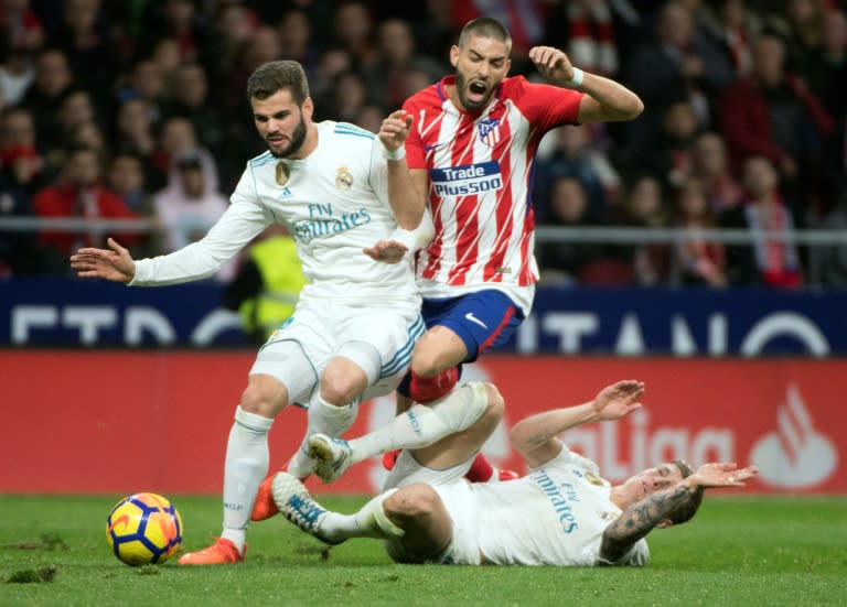 Atletico Madrid's Yannick Ferreira-Carrasco (C) vies with Real Madrid's Toni Kroos (R) and Nacho Fernandez during their match in Madrid on November 18, 2017