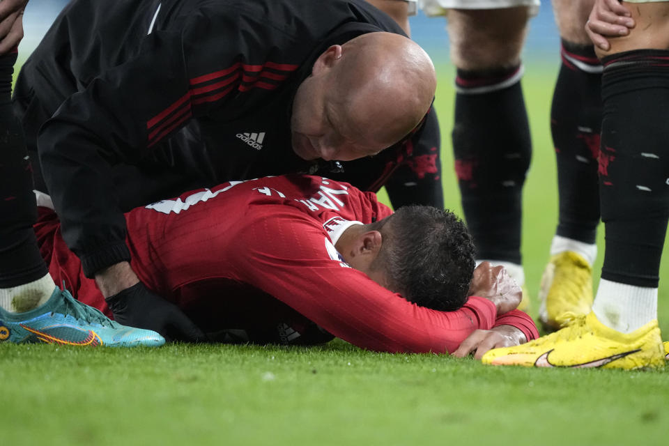 Manchester United's Raphael Varane lies injured on the ground during the English Premier League soccer match between Manchester United and Chelsea at the Stamford Bridge Stadium in London, Saturday, Oct. 22, 2022. (AP Photo/Frank Augstein)