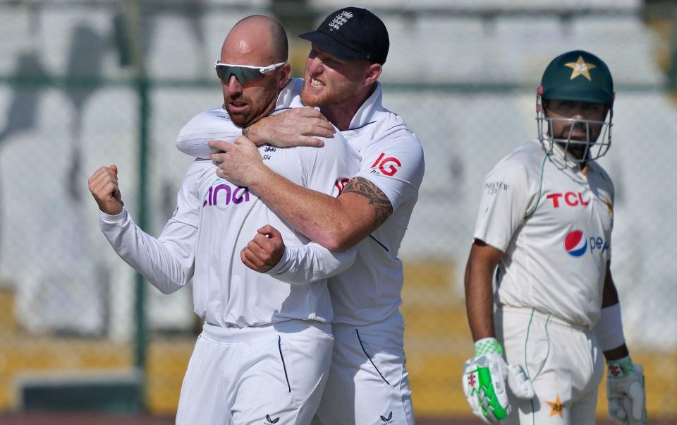 England's Jack Leach, left, celebrates with teammate Ben Stokes, center, after taking the wicket of Pakistan's Abdullah Shafique during the third day of third test cricket match between England and Pakistan, in Karachi, Pakistan, Monday, Dec. 19, 2022