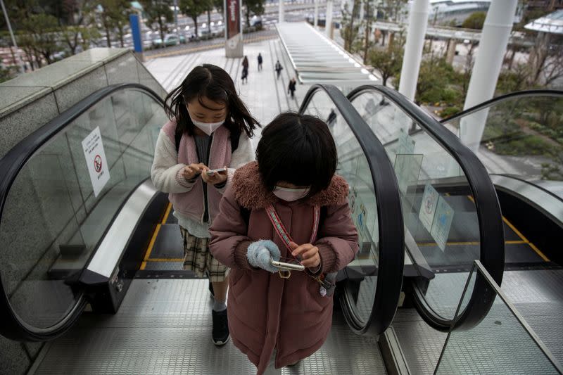 Children wearing face masks, following an outbreak of the coronavirus, are seen on a street in Tokyo