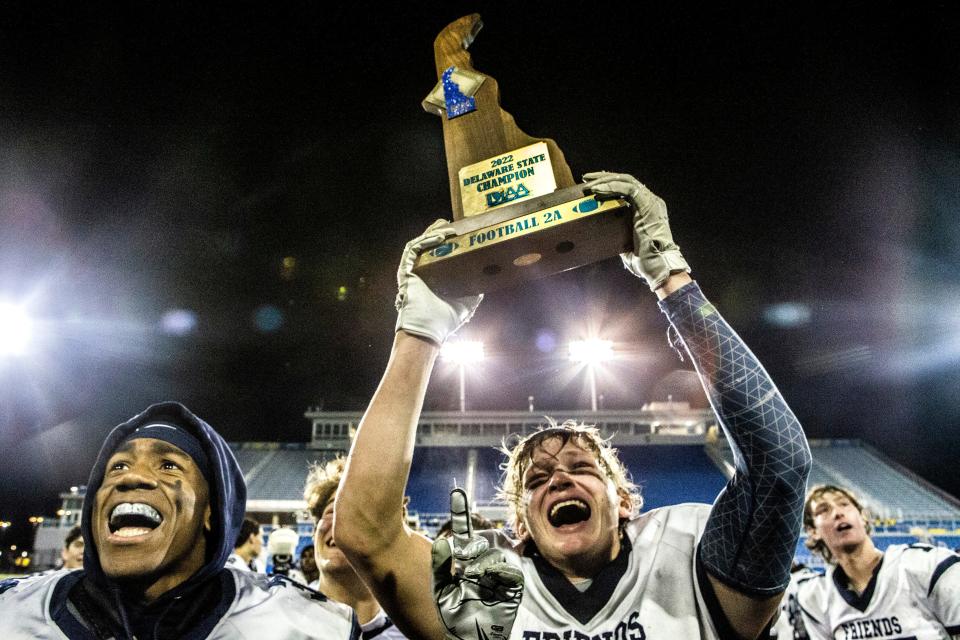 Ecstatic Wilmington Friends teammates, senior Jaden Willie (left) and Colin Harron hold up the 2022 Delaware State Champion trophy, celebrate with the fans after their 10-7 victory over Caravel during DIAA Class 2A football championship game at Delaware Stadium in Newark, Saturday, Dec. 10, 2022.