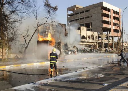 Firefighters work to extinguish flames at the scene of a car bomb attack in Kirkuk August 23, 2014. REUTERS/Ako Rasheed