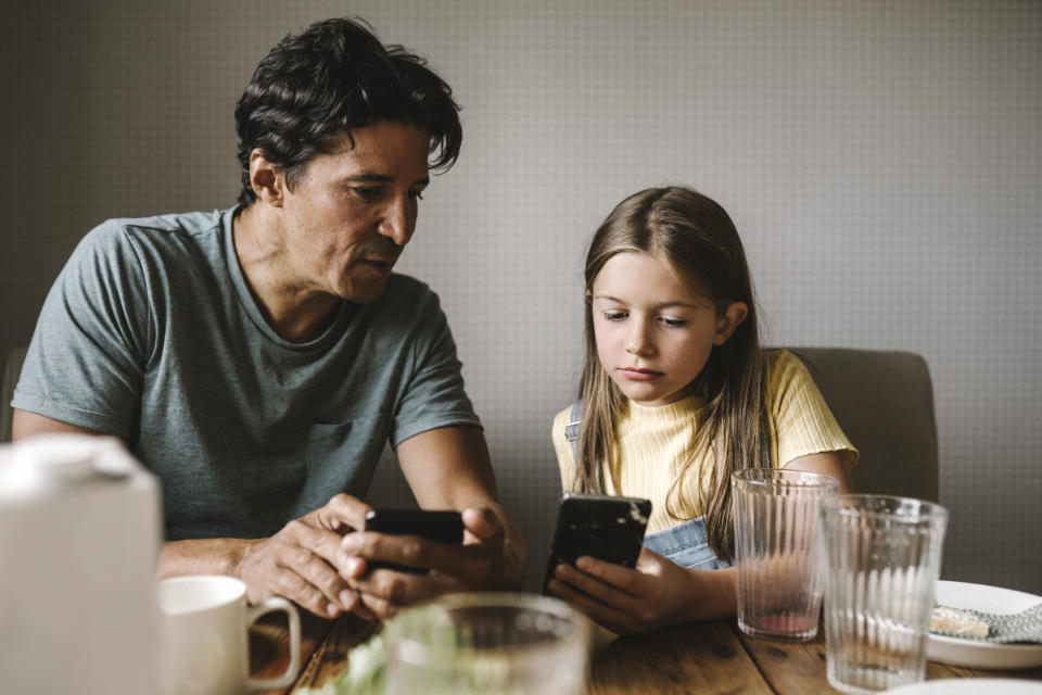 A father and daughter are at the dining table