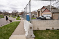 Fencing and concrete barriers surround the home of former Brooklyn Center police officer Kim Potter as local police guard her residence, Wednesday, April 14, 2021, in Champlin, Minn. A prosecutor said Wednesday that he will charge Potter, a white former suburban Minneapolis police officer with second-degree manslaughter for killing 20-year-old Black motorist Daunte Wright in a shooting that ignited days of unrest and clashes between protesters and police. (AP Photo/John Minchillo)