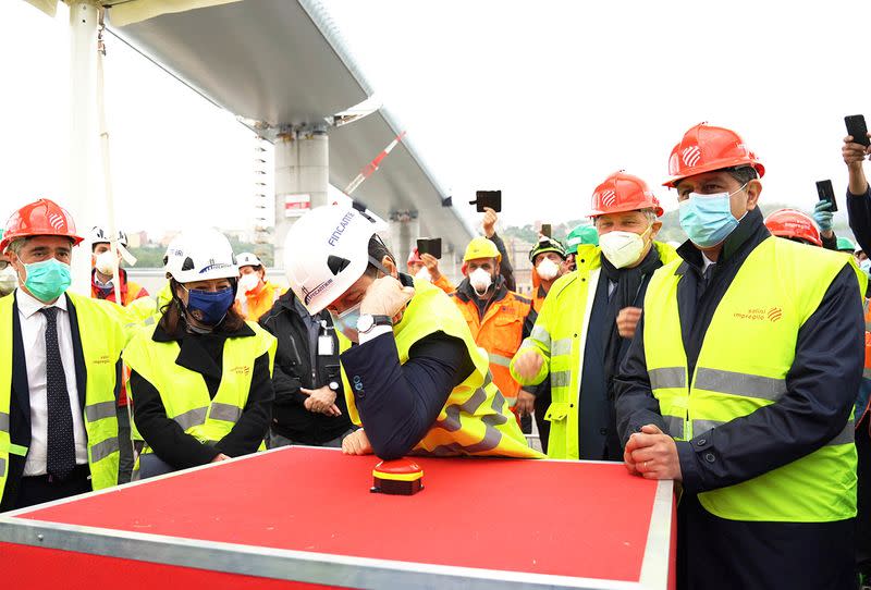 Italian Prime Minister Giuseppe Conte wearing a protective face mask attends the inauguration ceremony of the final section of Genoa's new bridge being installed into place and completing the rebuilding of the structure, in Genoa